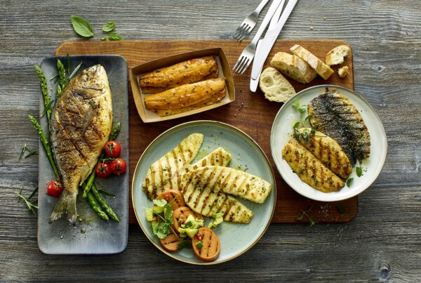 Deutsche See Fischmanufaktur startet mit vier handveredelten Produkthighlights in die Grillsaison 2026: dem Lachsfiletspieß „Chicorée“, der Dorade „Rauchpaprika“, dem Tilapia „Caipirinha“ und dem Heringsfilet „Knoblauch-Chili“. © DeutscheSee