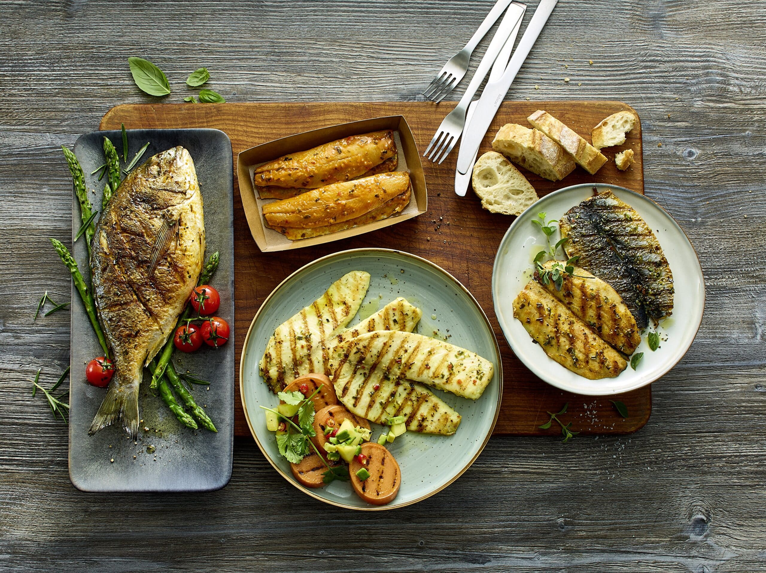 Deutsche See Fischmanufaktur startet mit vier handveredelten Produkthighlights in die Grillsaison 2026: dem Lachsfiletspieß „Chicorée“, der Dorade „Rauchpaprika“, dem Tilapia „Caipirinha“ und dem Heringsfilet „Knoblauch-Chili“. © DeutscheSee